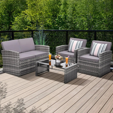 Four-Piece Outdoor Patio Furniture Set With Wicker Rattan Modular Sectional Sofa With Cozy Cushions And Glass Table All Weather Conversation Set For Garden Porch Backyard And Patio Light Gray on a deck.