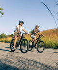Two adults riding Electric Hybrid Bike With 350W Hub Motor, 27-Inch Wheels, Throttle Or Pedal Assist, Up To 20 MPH, Dope Daily Commute Cruiser For Adults, Lightweight Blue Frame Built For Easy Hills And All Day Comfort on a paved trail.