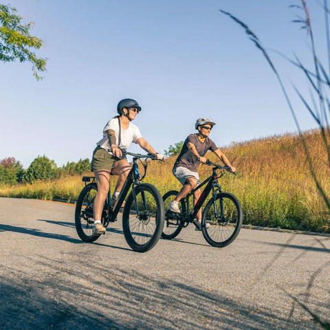 Two adults riding Electric Hybrid Bike With 350W Hub Motor, 27-Inch Wheels, Throttle Or Pedal Assist, Up To 20 MPH, Dope Daily Commute Cruiser For Adults, Lightweight Blue Frame Built For Easy Hills And All Day Comfort on a paved trail.