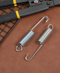 Pro Quality 4.5 Inch Recliner Springs 2 Pack Stainless Steel Tension Parts For Home Furniture on leather background with tools.