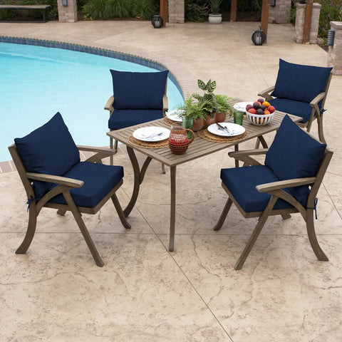 Outdoor Dining Chair Cushion Set 21 By 21 Inches In Sapphire Blue Rainproof And Fade Resistant Includes One Back Pillow And One Seat Bottom Eco Friendly PFAS Free C0 Treatment With Recycled Polyfill And Polyester Fill Fits Most Chairs installed on wooden chairs by a poolside table.