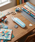 Hassle Free Cordless Electric Fabric Scissors With Ergonomic Comfort Grip No Sweat Battery Powered Heavy Duty Steel Blades Compact on craft table with fabric and tools.