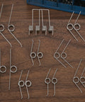 Packove 36 Pack Heavy Duty Torsion Spring Kit For Garbage Can Lid Replacement With 9 Sizes And Smooth Automatic Closure Perfect Trash Bin Repair Parts For Easy Home And Auto Waste Management, assorted steel springs on wood
