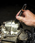 Hand using rechargeable area light with 1000 Lumen COB to illuminate engine, showing durable aluminum body in garage setting