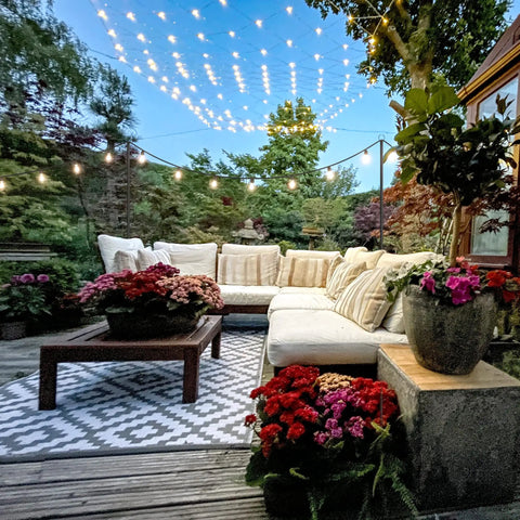 4 Pack Outdoor String Light Poles 10.5 Ft Tall With Screw In Dirt Insertion Over 20 Inches illuminating a patio with seating.