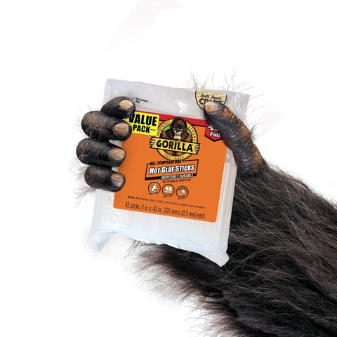 Gorilla hand holding pack of Weatherproof Hot Glue Sticks 4 Inches Long By 0.43 Inches Diameter Clear Pack Of Two With 90 Sticks