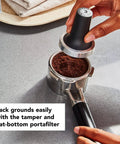 Hands using tamper on portafilter for Empire Red Metal Semi Automatic Espresso Machine With Dual Smart Temperature Sensors And 58mm Commercial Grade Portafilter For Consistent Barista Quality Espresso At Home