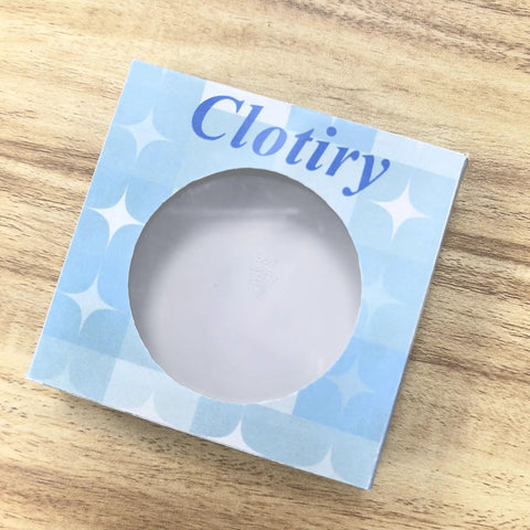 Blue Clotiry cardboard box with round window on wooden surface
