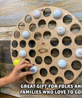 Charred Finish Golf Ball Display Holder And Collector Case Holds 42 Balls with hand placing ball, wall-mounted decor.