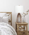 Vintage Farmhouse Wood Two Light Table Lamp With Netted Shade And Old Wood Base White Fabric Shade Dual Sockets 3 Way Bulb Capability Rotary Switch On Socket Rustic Charm For Living Room Or Hallway Cozy Farmhouse Vibe on bedside table