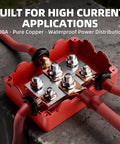 Heavy Duty Copper Bus Bar Power Distribution Block Set With Waterproof Covers For 12V 500A Systems on stone surface with wires.