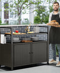 Outdoor Storage Cabinet With Wheels And Black Glass Top For Patio And Poolside No Fuss All Weather Wicker Cart With 56 Gallon Open Space And 70 Gallon Cabinet Side Hooks For Easy Organization Dark Brown shown on a patio with food and drinks.