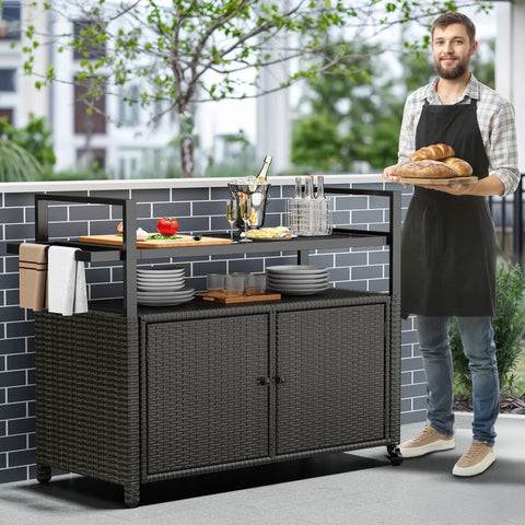 Outdoor Storage Cabinet With Wheels And Black Glass Top For Patio And Poolside No Fuss All Weather Wicker Cart With 56 Gallon Open Space And 70 Gallon Cabinet Side Hooks For Easy Organization Dark Brown shown on a patio with food and drinks.