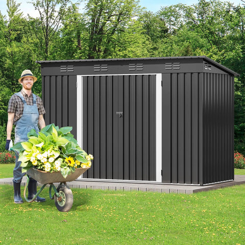 Gardener beside a 9x4 Outdoor Storage Shed With Windows And Lockable Double Doors Tough As Nails Steel Construction Sloped Roof.
