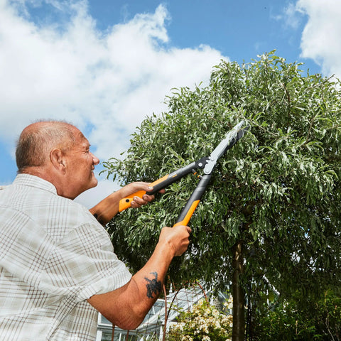 Man trimming tree with 23 Inch Hedge Shears With PowerGear2 Technology That Multiplies Power For Less Effort, SoftGrip Handles.