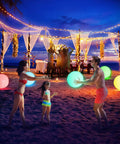 Family playing with 16 Inch Light Up Glow Beach Ball With 8 LED Modes For Night Pool Fun on a beach at sunset, colorful balls lit.