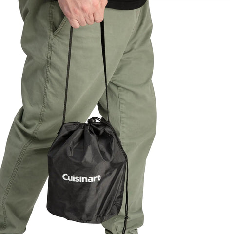 Person carrying compact Smokeless Tabletop Fire Pit For Patio And Camping in black carry bag, showcasing portability.