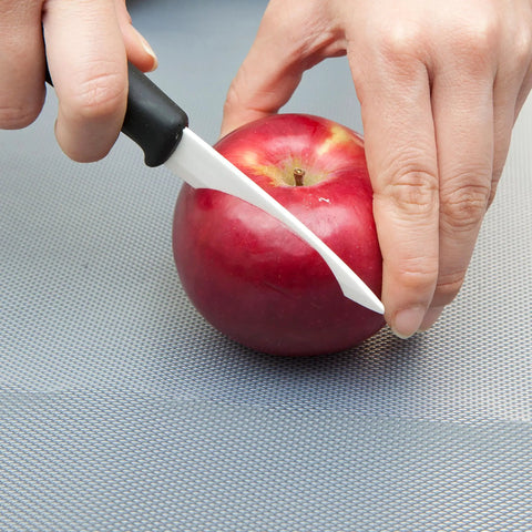 Slicing an apple on EZ Board Disposable Plastic Cutting Board For Quick Cleanup And Easy Food Prep On The Go, 20 Square Feet.