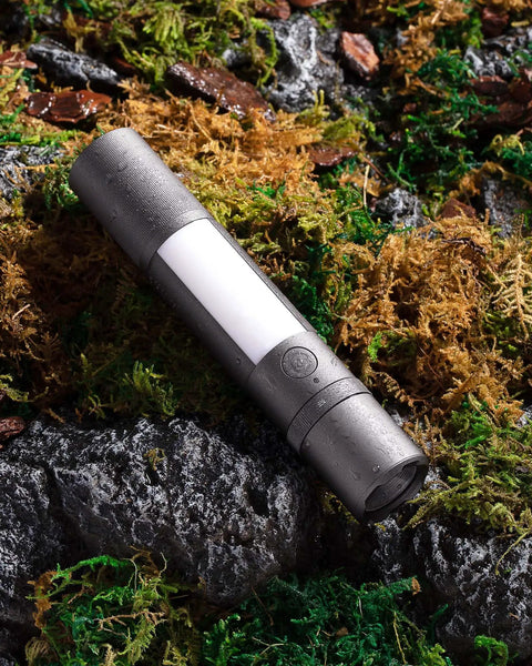 Rechargeable Magnetic LED Flashlight 1000 Lumens With Window Glass Breaker and Seat Belt Cutter resting on mossy rock.