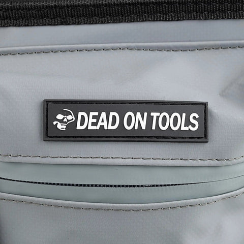 "Dead on Tools" logo on 18 Inch FlatTop Weather Resistant Tool Bag With All Terrain Bottom And Weatherproof Front Pocket 12 Interior Pockets Removable Padded Shoulder Strap Gray Assembled In The USA.