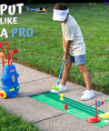 Child playing with Fun Tot Golf Set For Kids with 4 Lightweight Clubs, 6 Soft Balls, 2 Practice Holes, Mini Putting Mat on sidewalk