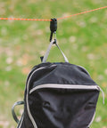Camp Carabiner For Hanging Towels, Lights, Packs And Small Gear On 550 Paracord With 1/4-20 Attachment Point, 360 Degree Swivel For Easy Access To Your Gear While Camping shown hanging a backpack.
