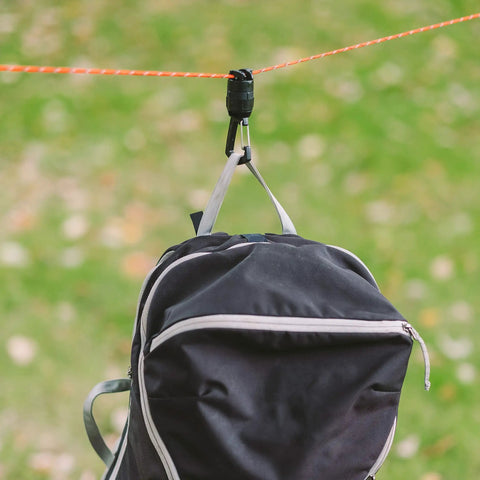 Camp Carabiner For Hanging Towels, Lights, Packs And Small Gear On 550 Paracord With 1/4-20 Attachment Point, 360 Degree Swivel For Easy Access To Your Gear While Camping shown hanging a backpack.
