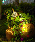 Watering Can Solar Lights With Cascading Glow For Outdoor Vibe Hanging Lantern illuminating garden plants at night