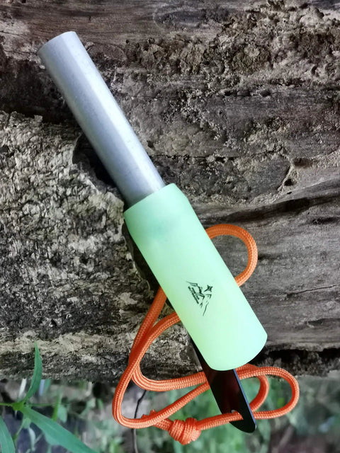 Grab And Go Emergency Fire Starter Kit With Magnesium And Ferro Rods, luminous green handle, orange paracord lanyard, on wood surface
