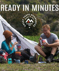 Two backpackers enjoying Gluten Free Korean Inspired Beef Freeze Dried Trail Ready Camping Meal For Backpackers next to their tent.
