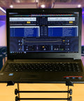 Portable DJ Laptop Stand With Adjustable Height holding a laptop, displaying music software, in a studio setting