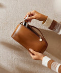 Travel Makeup Bag For Women With Large Capacity, Waterproof Cosmetic Pouch being opened by a person, brown, medium size