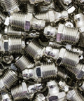 Pile of metal fittings from All In One Grease Fitting Tool For 1/8 And 7/16 NPT used in cars, trucks, tractors, and heavy equipment.