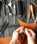 Hands working with Waxed Leather Sewing Thread Kit With 55 Yard Spools And Pro Grade Needles for upholstery repair.