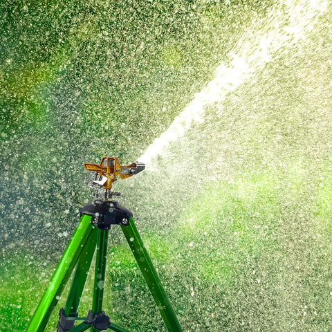 Impact Sprinkler On Tripod Base With Brass Head, spraying water at 360 Degree Coverage, in garden setting