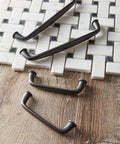 Kane Black Bronze Cabinet Pull Transitional Style Drawer Handle for Cabinets and Furniture on wooden and tile background