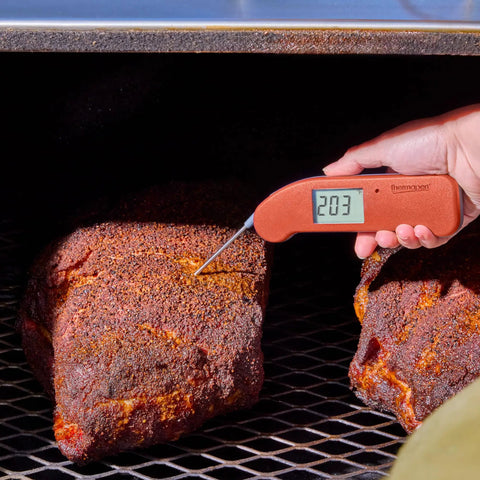 Hand using Top Rated No. 1 Instant-Read Thermometer For Precision Cooking, One-Second Read, Cayenne Pepper Red, on grilled meat