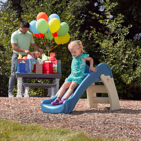 Toddler sliding on Play And Fold Junior Slide For Toddlers 1.5 To 4 Years Old Indoor Outdoor Backyard Playground Set at a party.