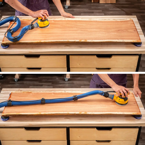 Woodworker using One And A Half Inch Sliding Dust Hose Cord Clips For Shop Vac Hoses And Cords on a wooden board in a woodshop.