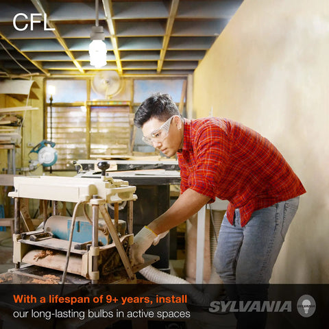 Person working under CFL light bulb with lifespan of over nine years in an active space.