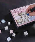 Close-up of hand using tool to change keycaps on Cute Bubble Cat Wireless Mechanical Keyboard Hits Different With Creamy 75 Percent Layout Hot Swappable Switches Cat Ear Shine Through Keycaps Triple Mode RGB Gaming Board For Mac And PC Users Wanting Top Tier Vibes.
