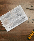 Open box of Heavy Duty Drywall Anchors And Toggle Bolts Kit, 32 Pcs Metal Wall Fasteners on wooden table with screwdriver