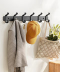 Wall Mounted Heavy Duty Metal Coat Rack With Six Hooks For Coats Hats Bags Robes Keys And Towels Entryway Mudroom Or Closet Organizer In Rust Resistant Black Finish with coat and hat hanging.
