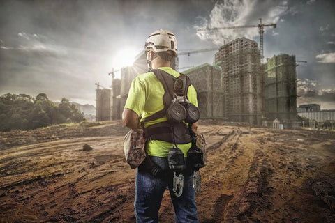 Worker at construction site wearing H1 V-Gard Safety Helmet With Fas-Trac III Ratchet Suspension, Polyethylene Shell, Black