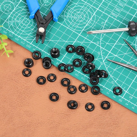 Top view of black #8 stainless steel countersunk cup washers, 200 pcs, scattered on green cutting mat with pliers.