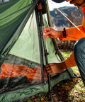 Person setting up Forest Scout Backpack Tent for Quick Camp Setup Lightweight Frame Shelter With 1000mm PU Coated Polyester
