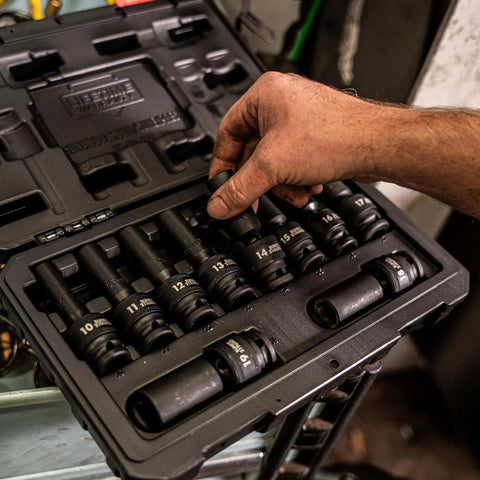 Hand selecting a socket from the Ten Piece One Half Inch Drive Deep Universal Metric Impact Socket Set With Radius Corner Design