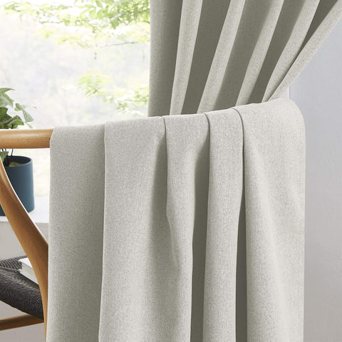 Close-up of 100 Percent Blackout Linen Curtains in Greyish Beige, 50x126 Inches, Two Panels draped over a chair in a living room.
