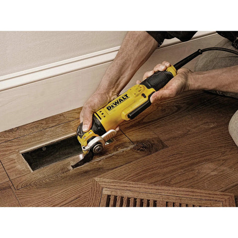 Person using Oscillating Multi Tool Kit With 3 Amp Motor Dual Grip Variable Speed Trigger Quick Change System on wooden floor