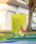 Front view of a yellow compost starter and odor reducer pack on a bin outdoors, featuring garden iconography.